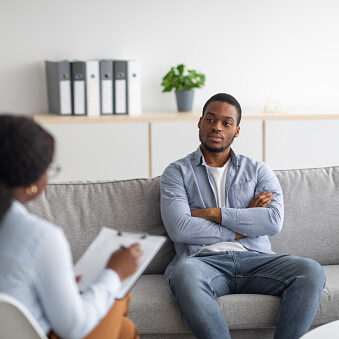 Psychological counselling. Black male patient with depression having session with psychotherapist at office. African American man with PTSD consulting mental health professional at clinic